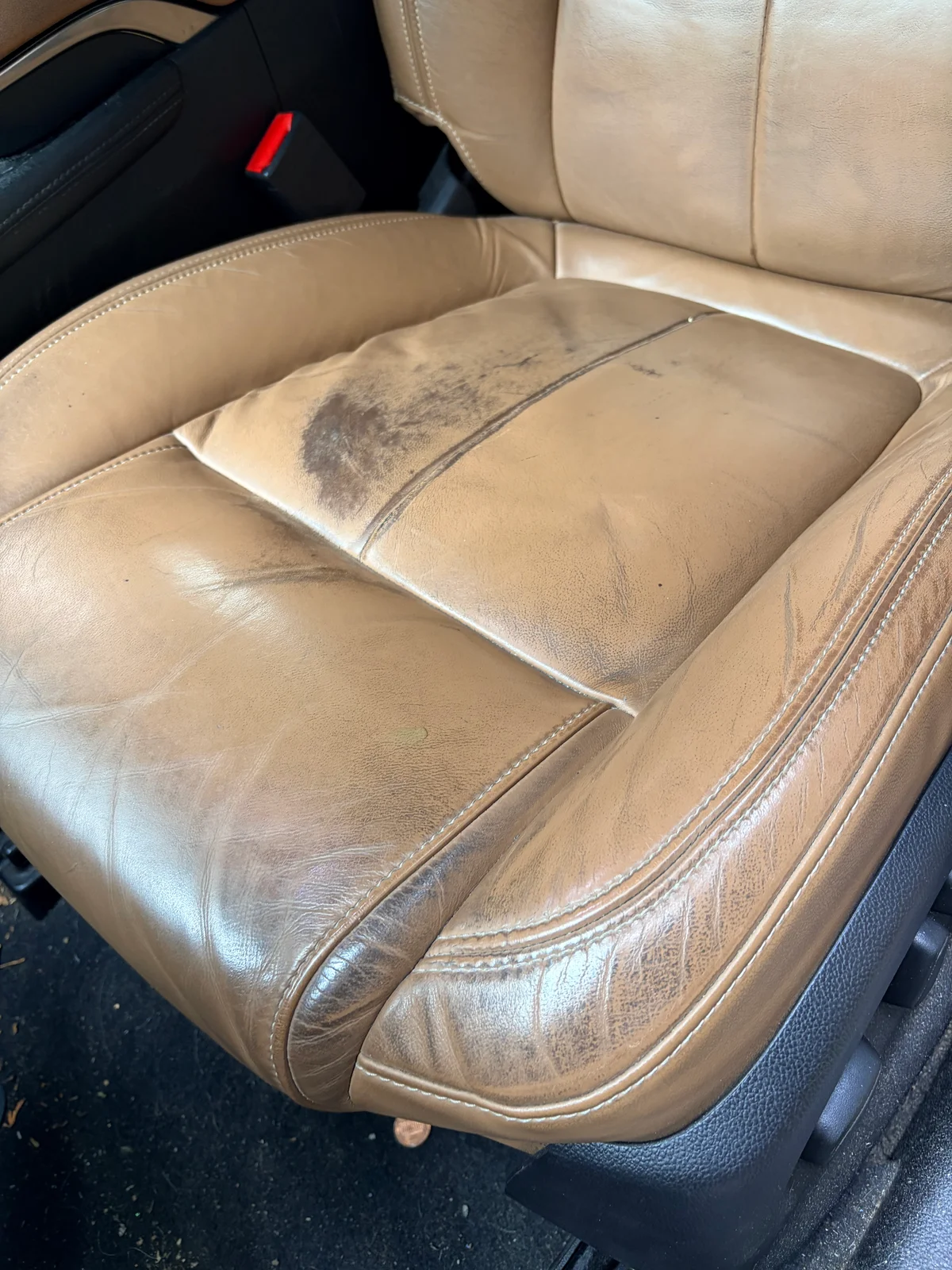 2015 Buick LaCrosse driver's seat before restoration — color loss, discoloration, and surface wear across the leather seating surface