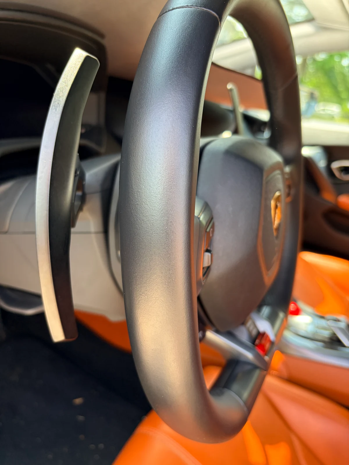 Lamborghini Huracán steering wheel after restoration — uniform sheen and texture across the complete wheel, Lamborghini shield badge visible