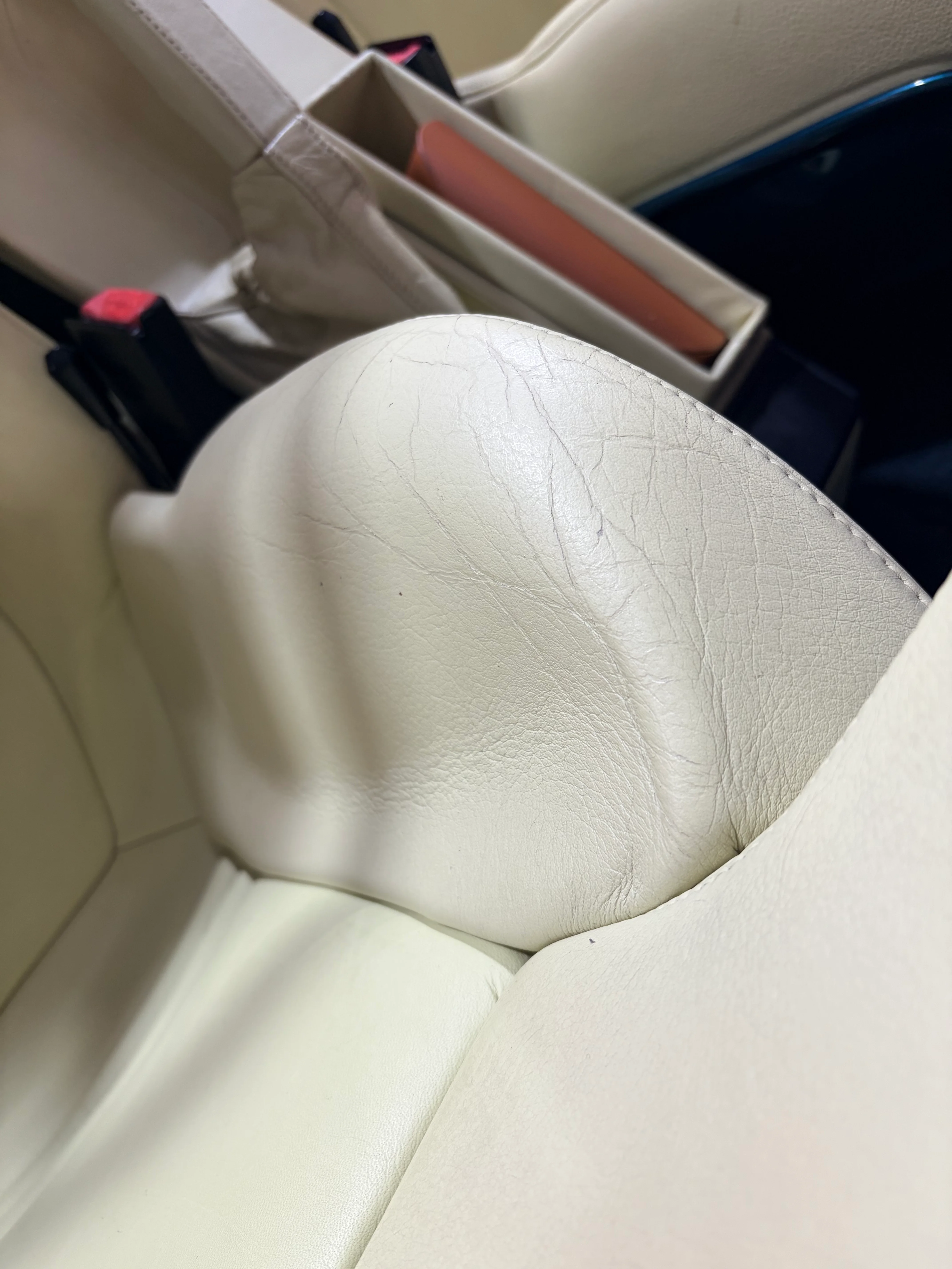 BMW Z1 headrest surface cracking before preservation — fine crazing at the curved edge where leather wraps the headrest form