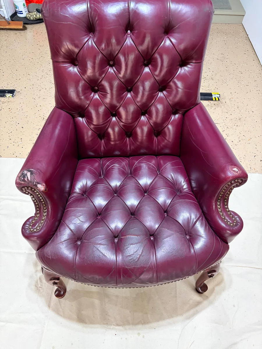 Vintage oxblood Chesterfield armchair before restoration — full chair condition before repair work began