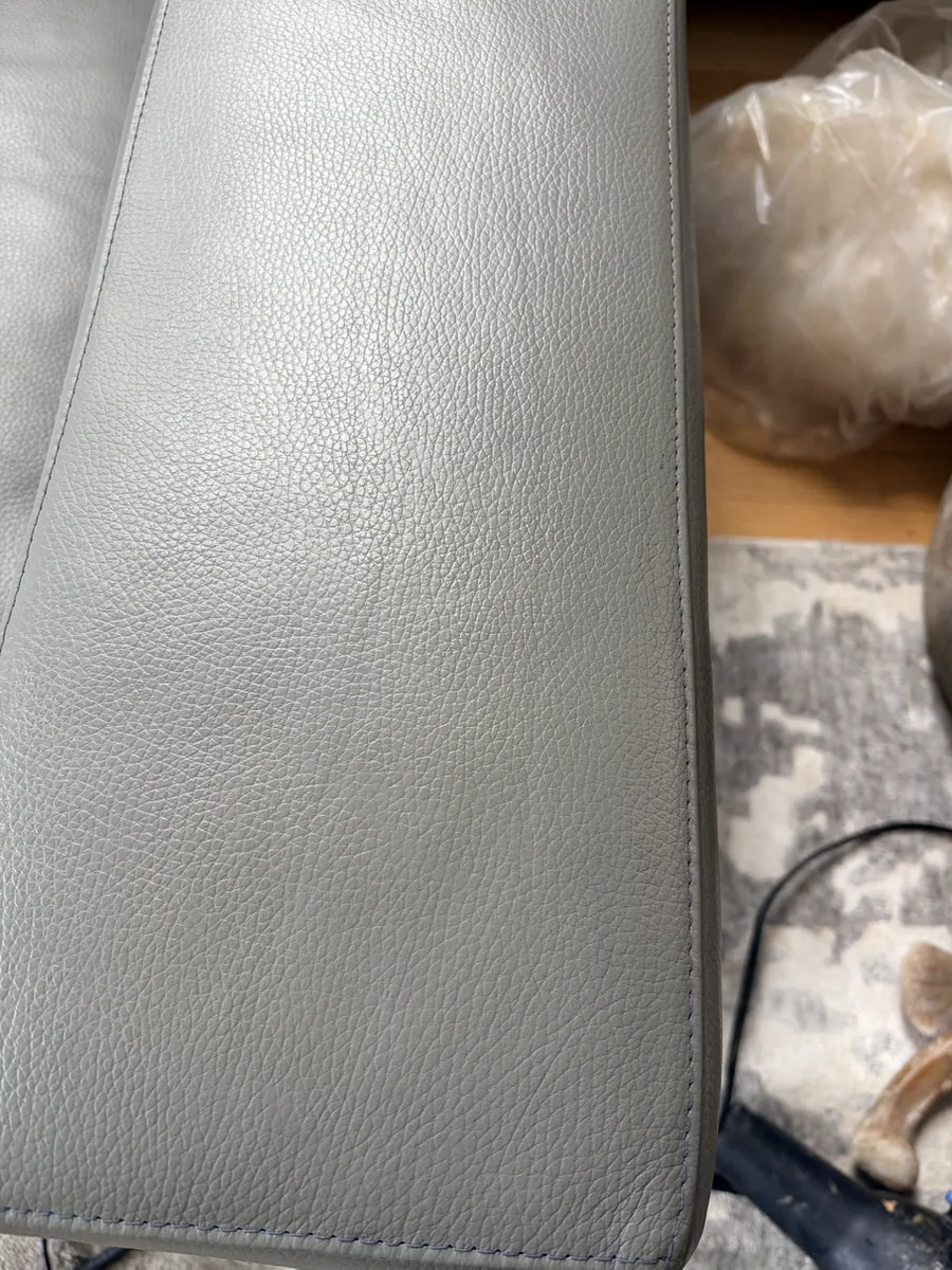 Close-up of the gray leather sofa arm after dog scratch finish restoration