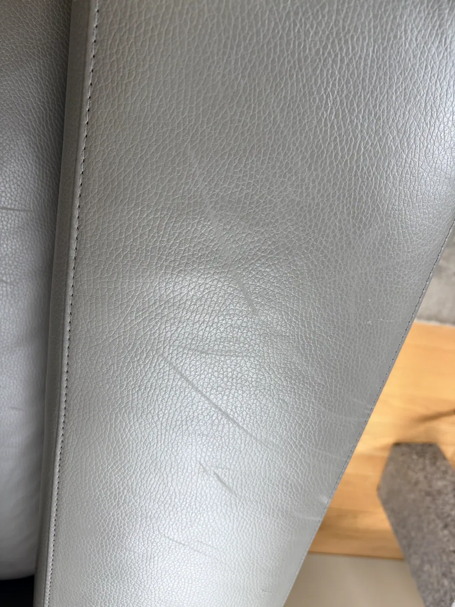 Surface scratches from a dog on the gray leather sofa arm in DUMBO before restoration