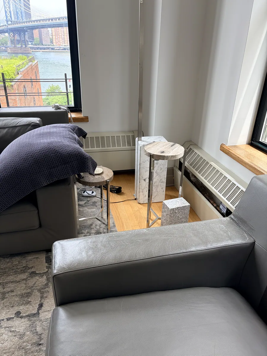 Protective finish restoration in progress on a gray leather sofa arm in DUMBO