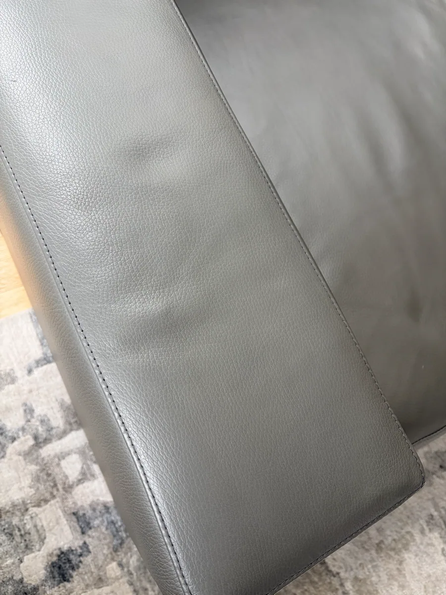Restored gray leather sofa arm with an even color and protective finish