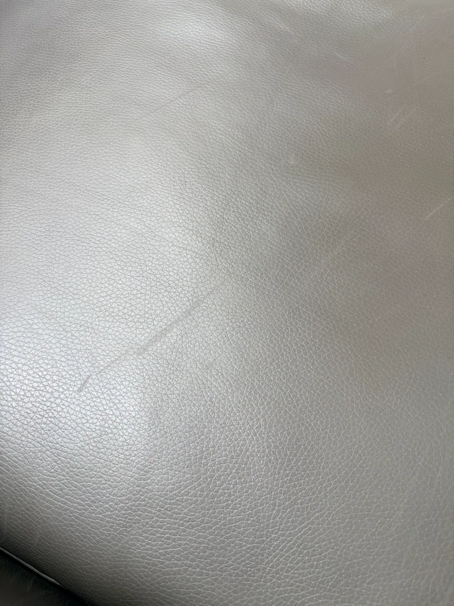 Close-up of scratched protective finish on the leather sofa seat