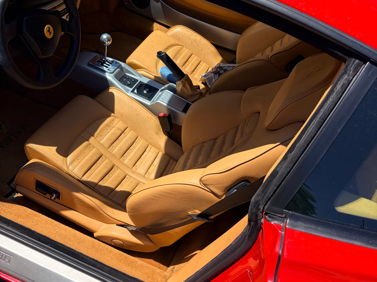 1999 Ferrari 360 Modena Rosso exterior with beige interior before leather restoration — both seats visible from open door