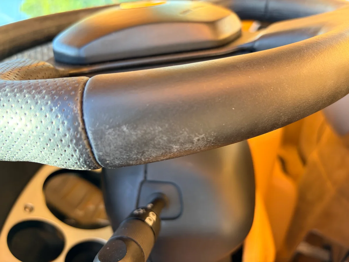 Ferrari 360 Modena steering wheel before restoration — severe discoloration and chalky surface breakdown on leather grip