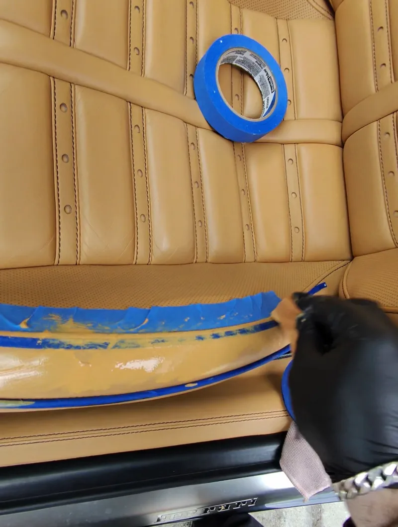 Ferrari 599 GTB seat cushion edge rip — flexible filler applied over masked repair area