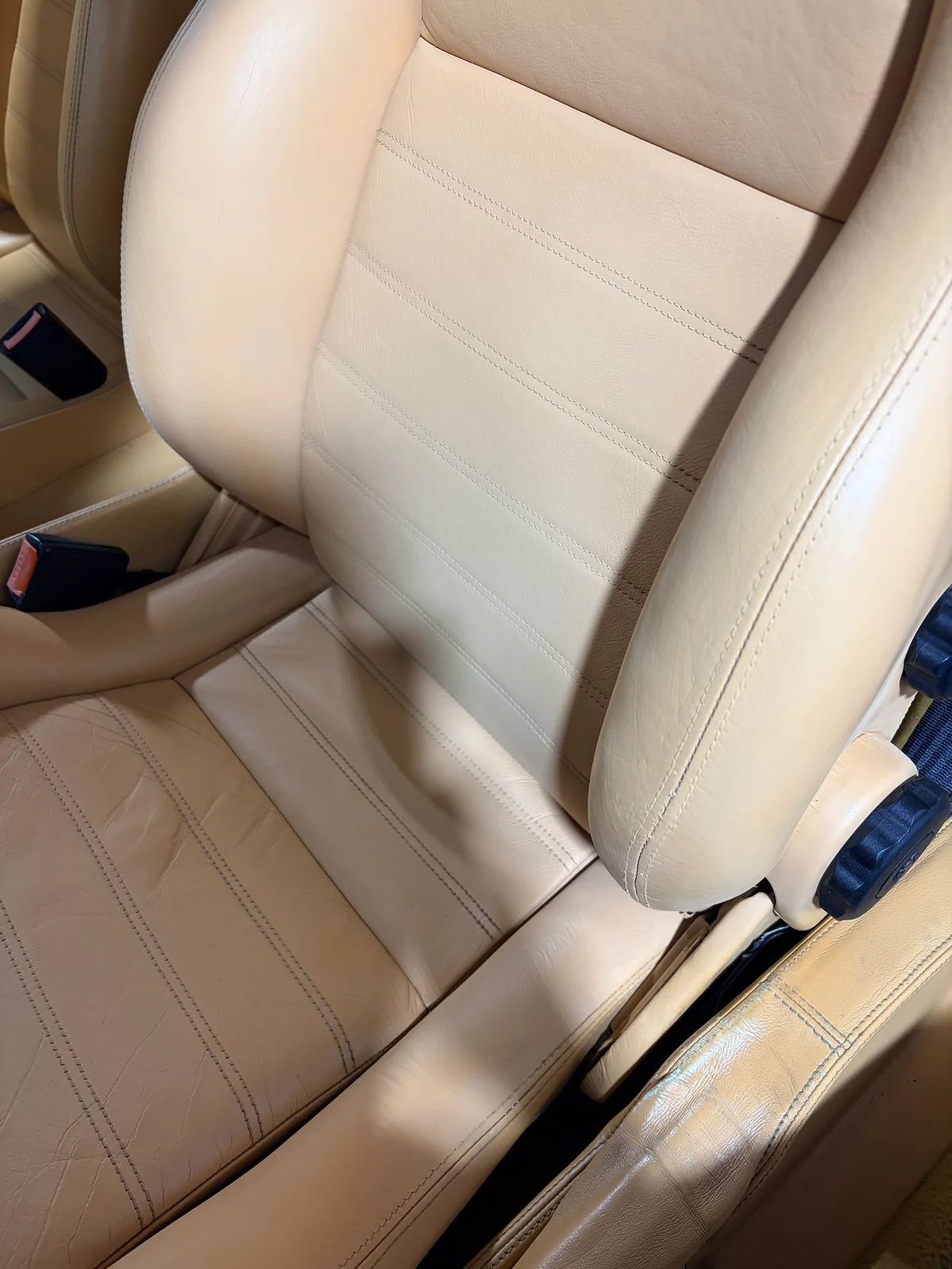 Ferrari F355 driver's seat after restoration — wider view showing bolster and seat back with natural leather creasing preserved