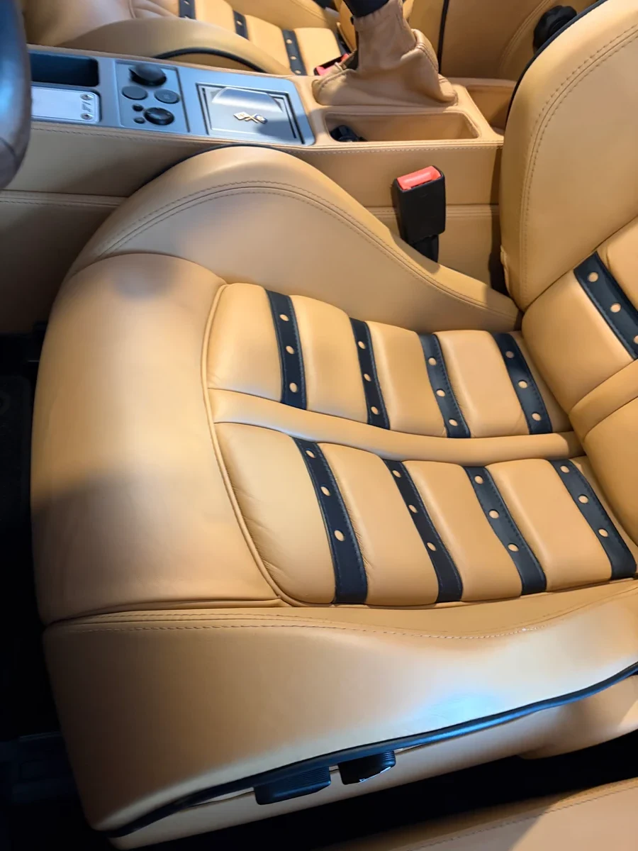 Ferrari F430 Spider driver's seat after restoration — Cuoio leather uniform and correct, black Daytona inserts clean, center console visible