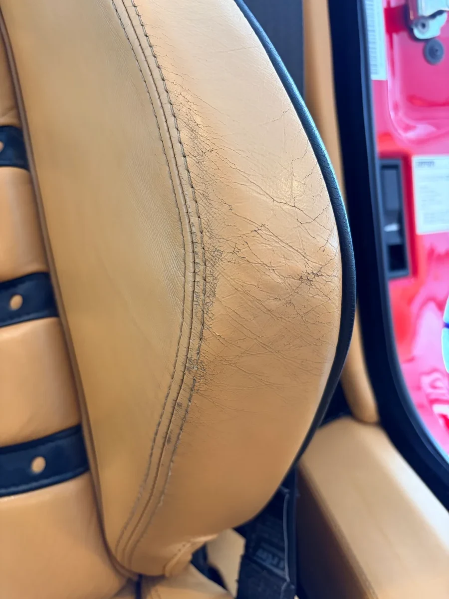 Ferrari F430 Spider seat bolster before restoration — cracking leather surface and wear from previous dealership refinishing