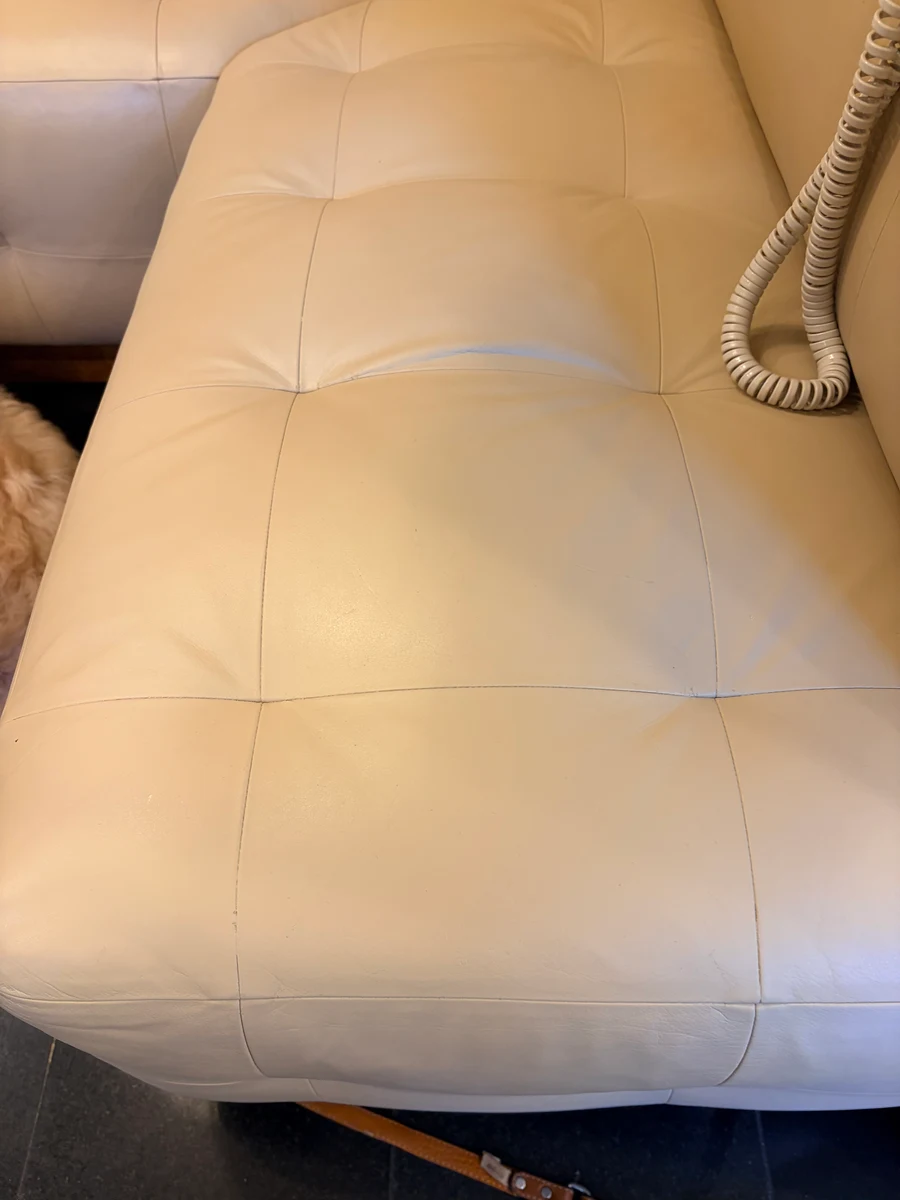 Restored cream leather banquette seat close-up — clean surface, no cracking, even color after professional leather restoration