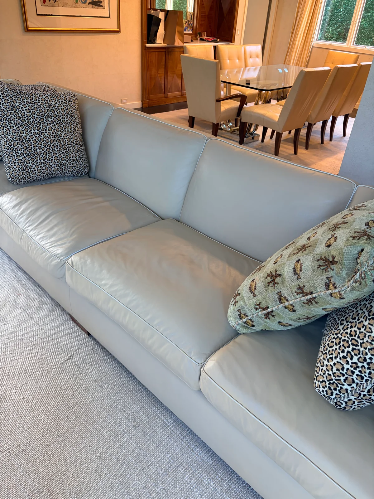 Restored leather sofa in New York residence — custom color coordinates with leather dining seating visible in the background, creating a unified interior