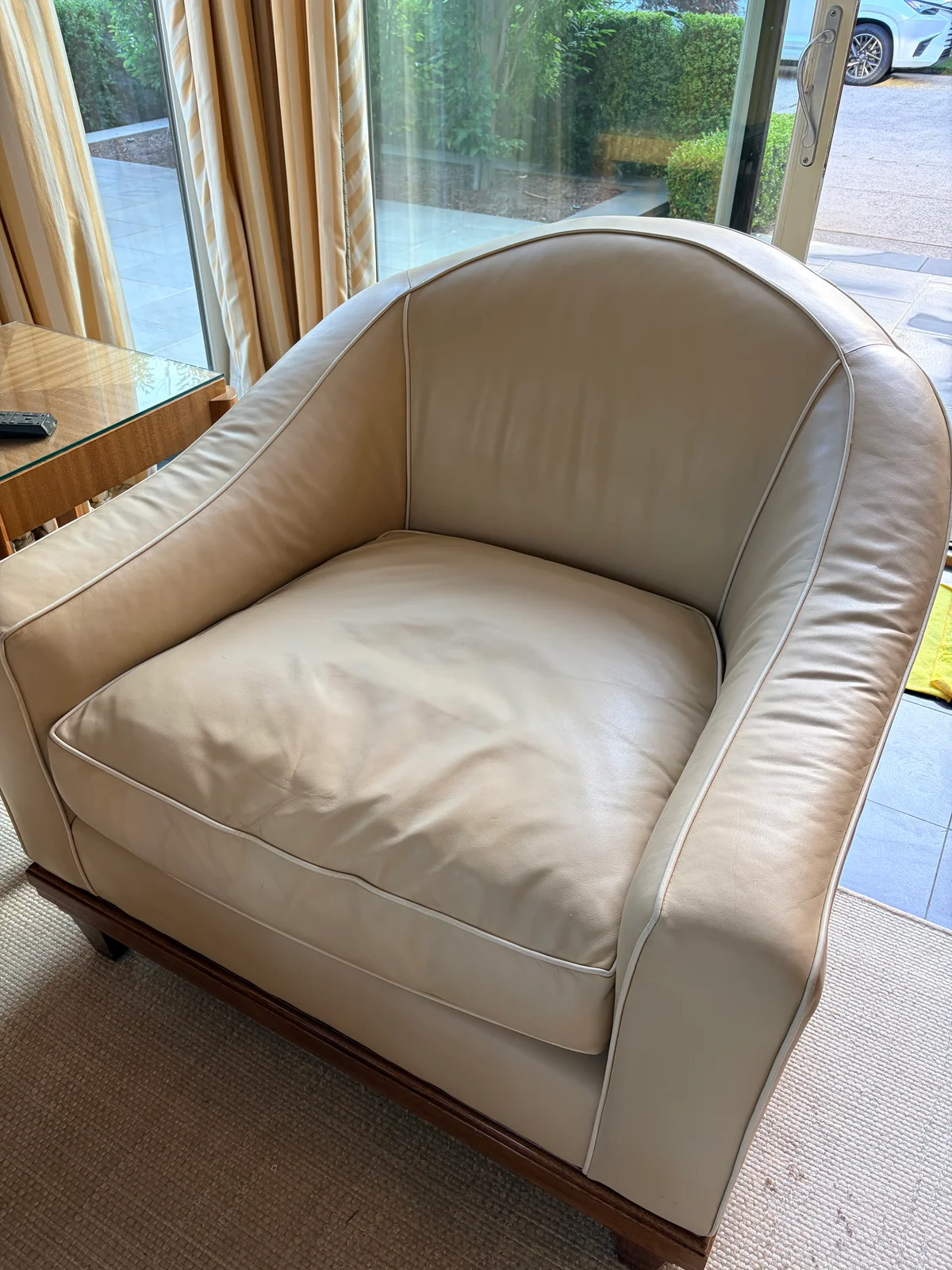 Luxury leather barrel-back club chair after professional restoration — custom color and preserved white contrast piping, New York