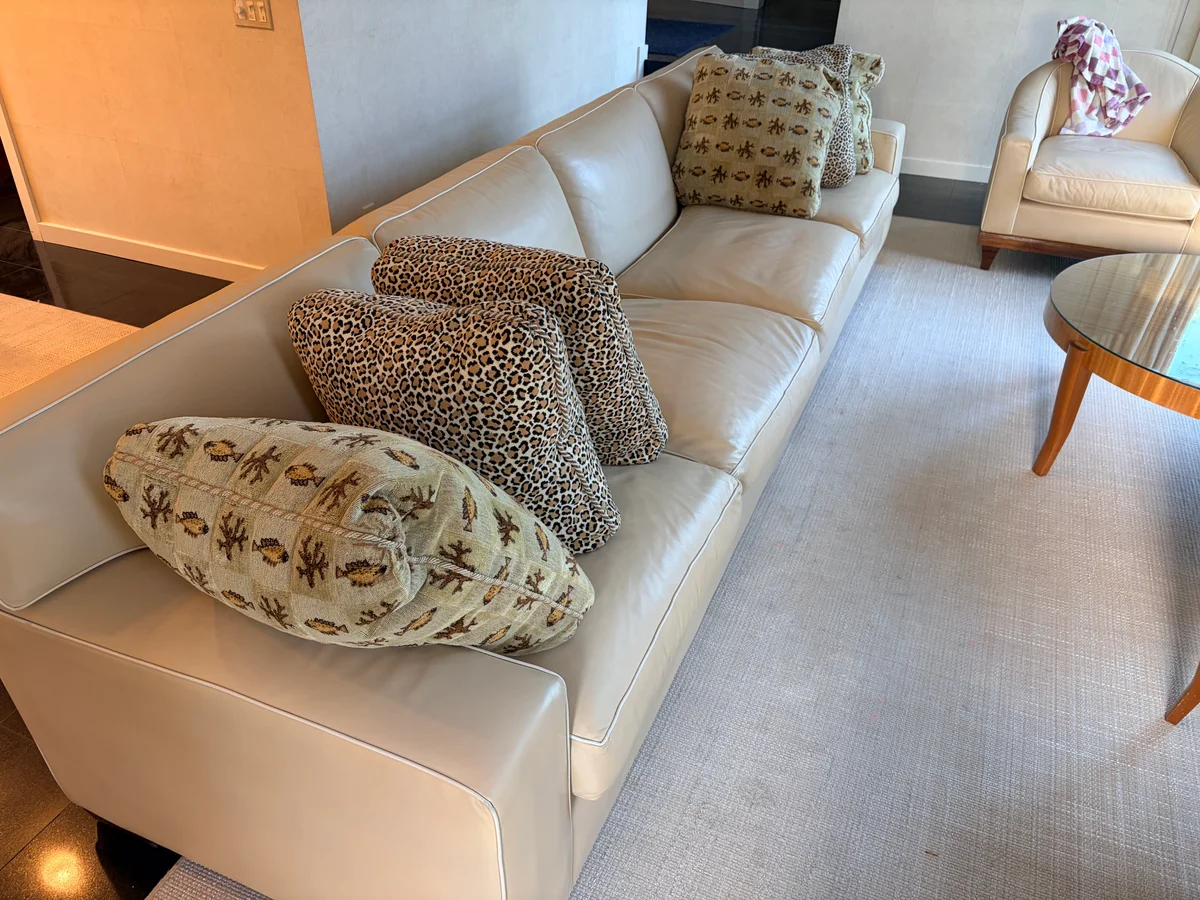 Luxury leather sofa and two club chairs after professional restoration in New York — custom color, white contrast piping preserved