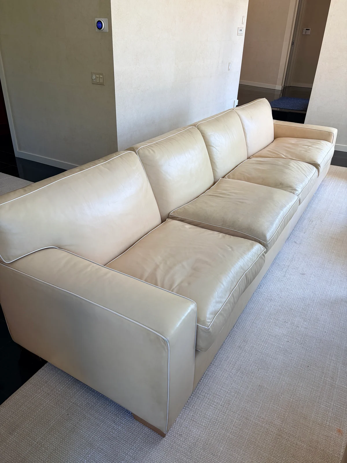 Luxury leather sofa before restoration — UV faded cream leather showing color loss and surface deterioration in New York residence