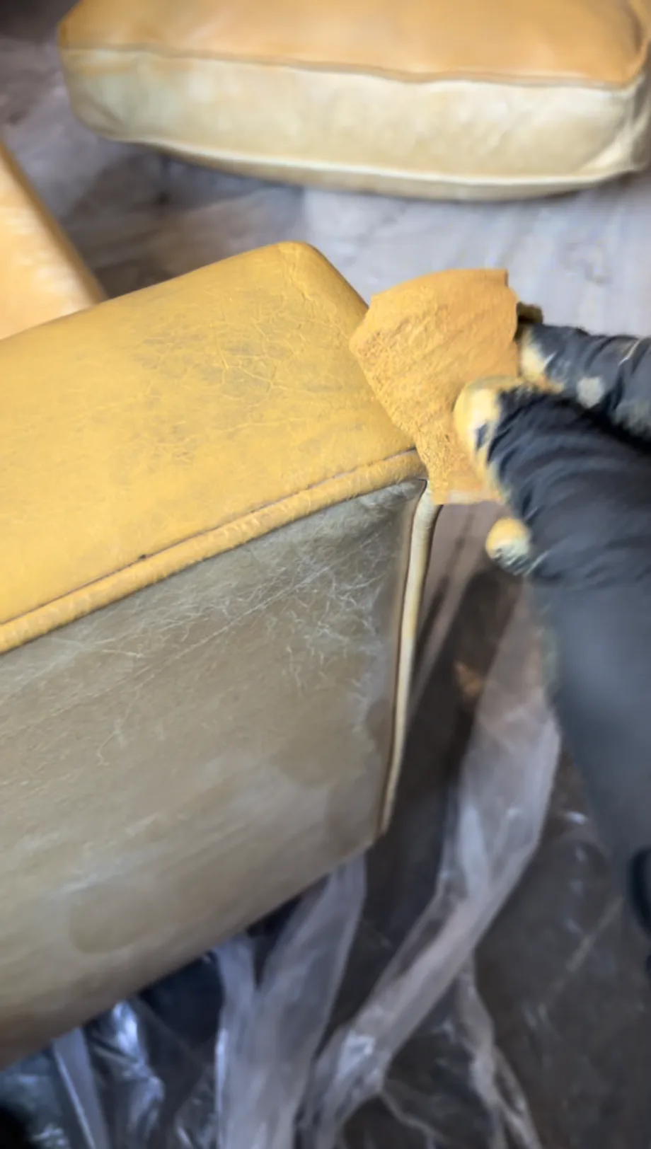 Leather & Vinyl Care technician applying custom Saffron leather pigment to Mitchell Gold Hunter chair armrest — on-site color restoration process