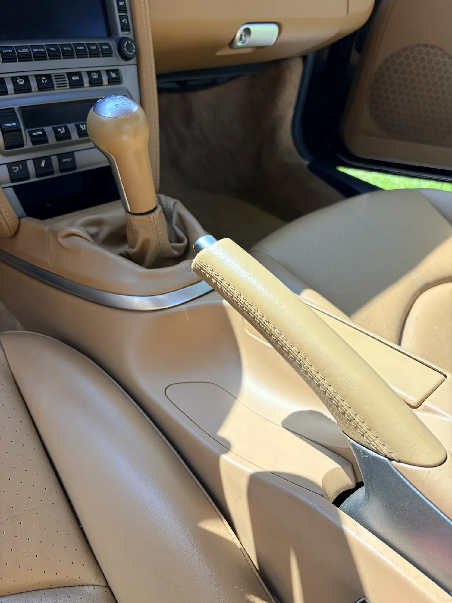 Restored tan Porsche manual gear shifter, parking brake, and center console