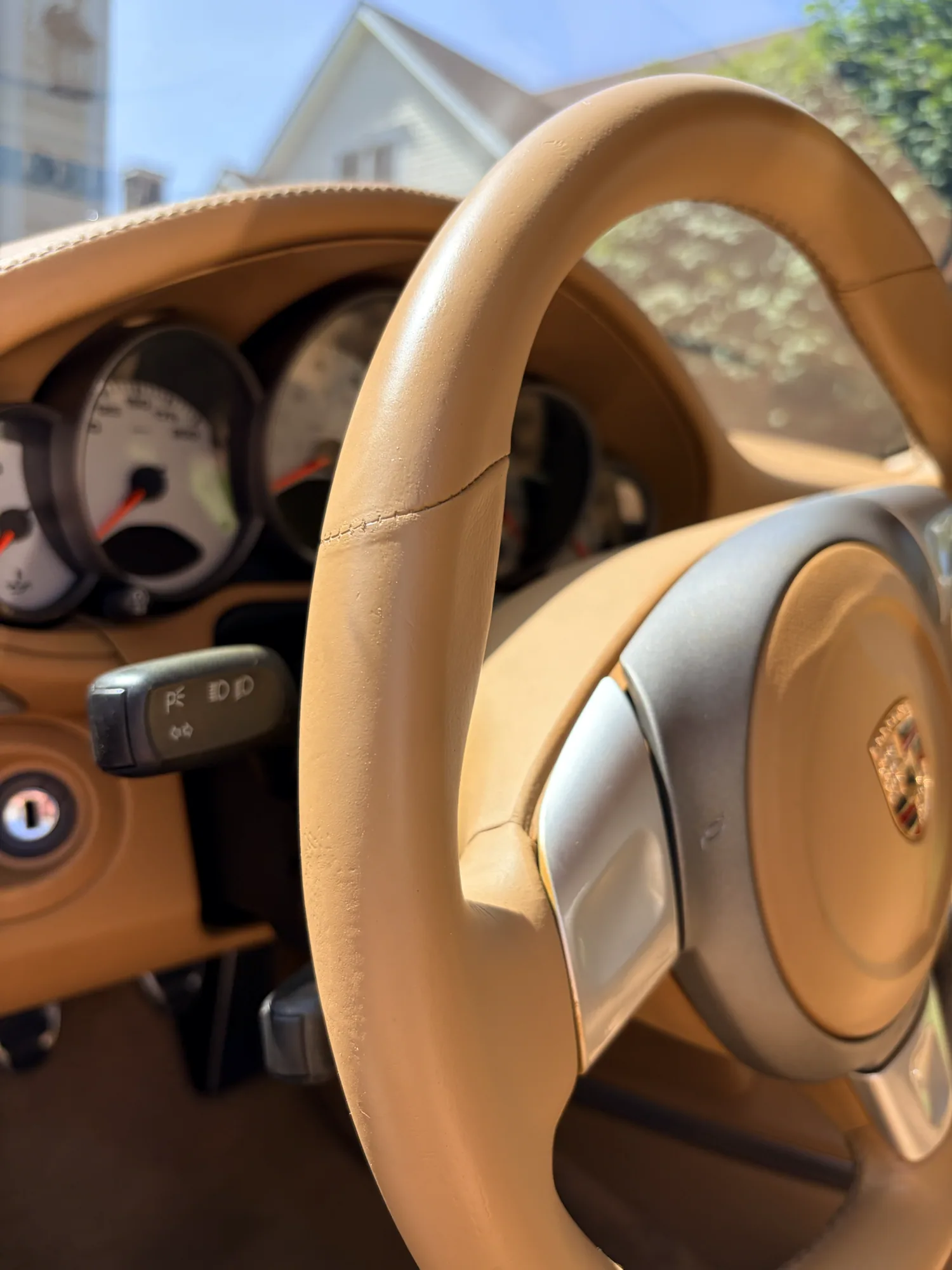 Tan Porsche steering wheel and instrument cluster surround after corrective color restoration