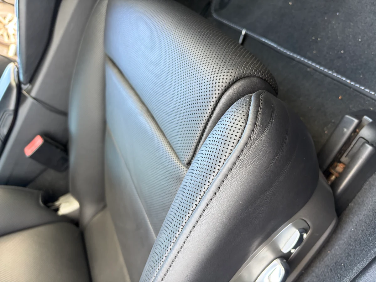 Porsche 911 Targa 4 driver seat bolster after restoration — lateral bolster repaired and recolored, perforated leather surface uniform and protective finish applied