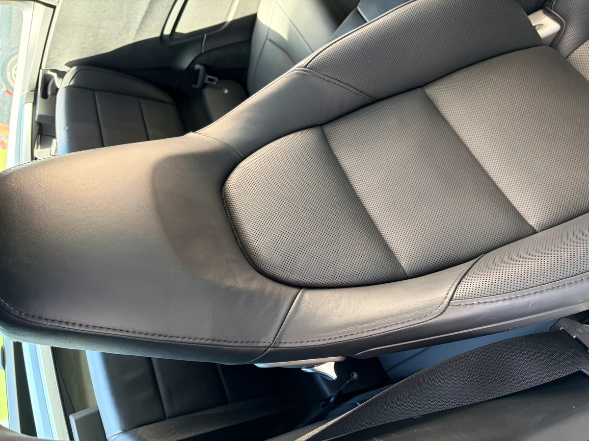 Porsche 911 Targa 4 driver seat after restoration — black perforated leather restored to uniform color and finish, bolster wear fully corrected