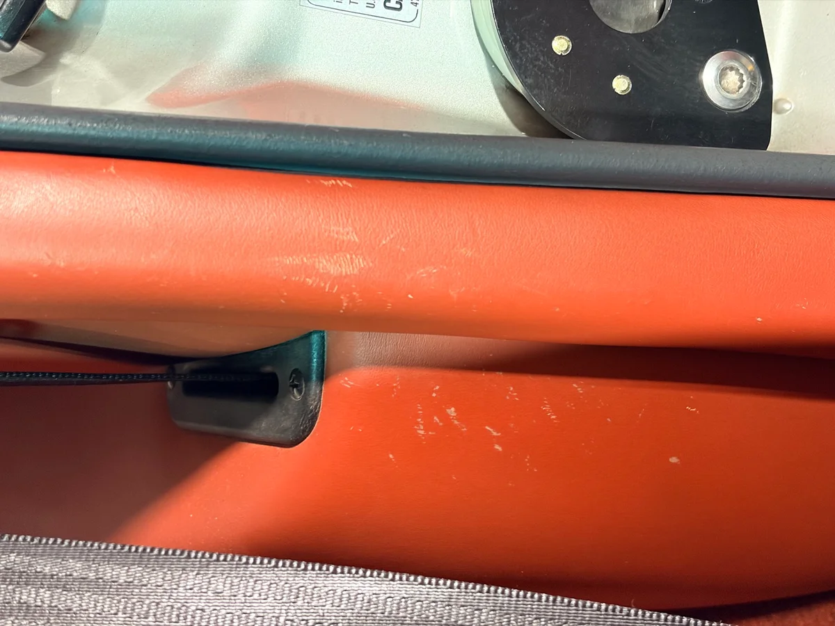 Porsche 993 door panel secondary area before restoration — light surface scratches and scuffs near door pull hardware