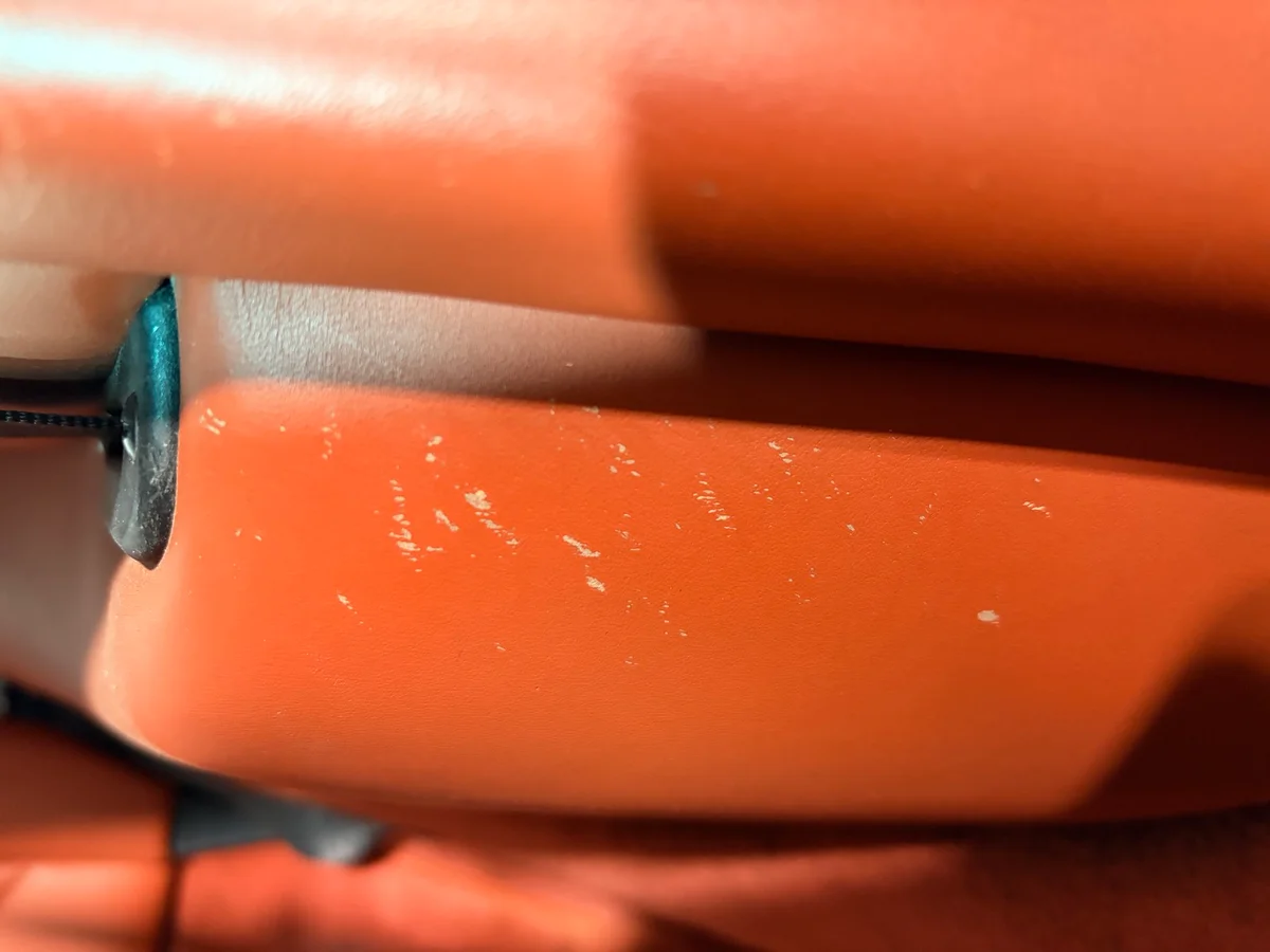 Porsche 993 lower seat area before restoration — surface finish worn and scratched near seat adjustment rail