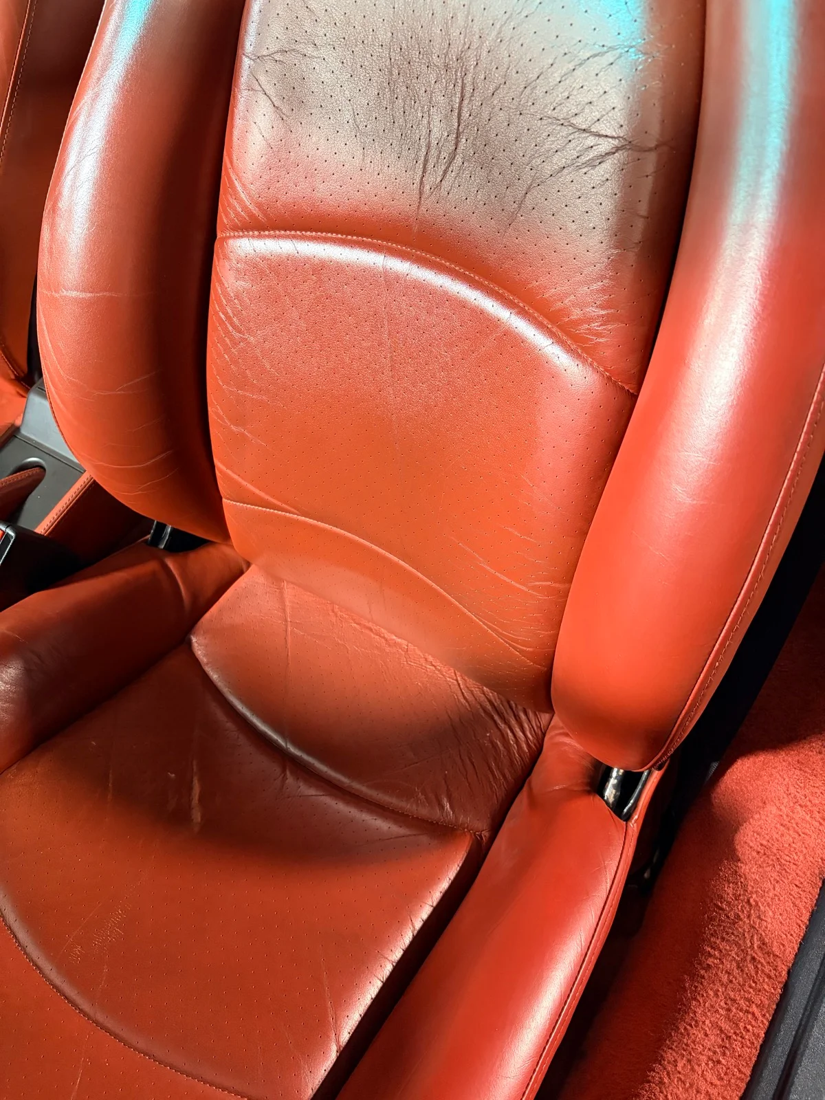 Porsche 993 Carrera S interior after restoration — driver and passenger seats showing consistent orange-red leather tone with natural character retained