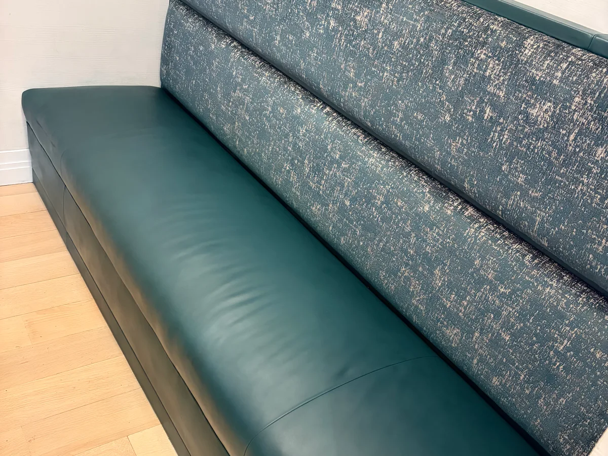 Teal leather sofa side view after restoration — arm and frame leather even, no discoloration