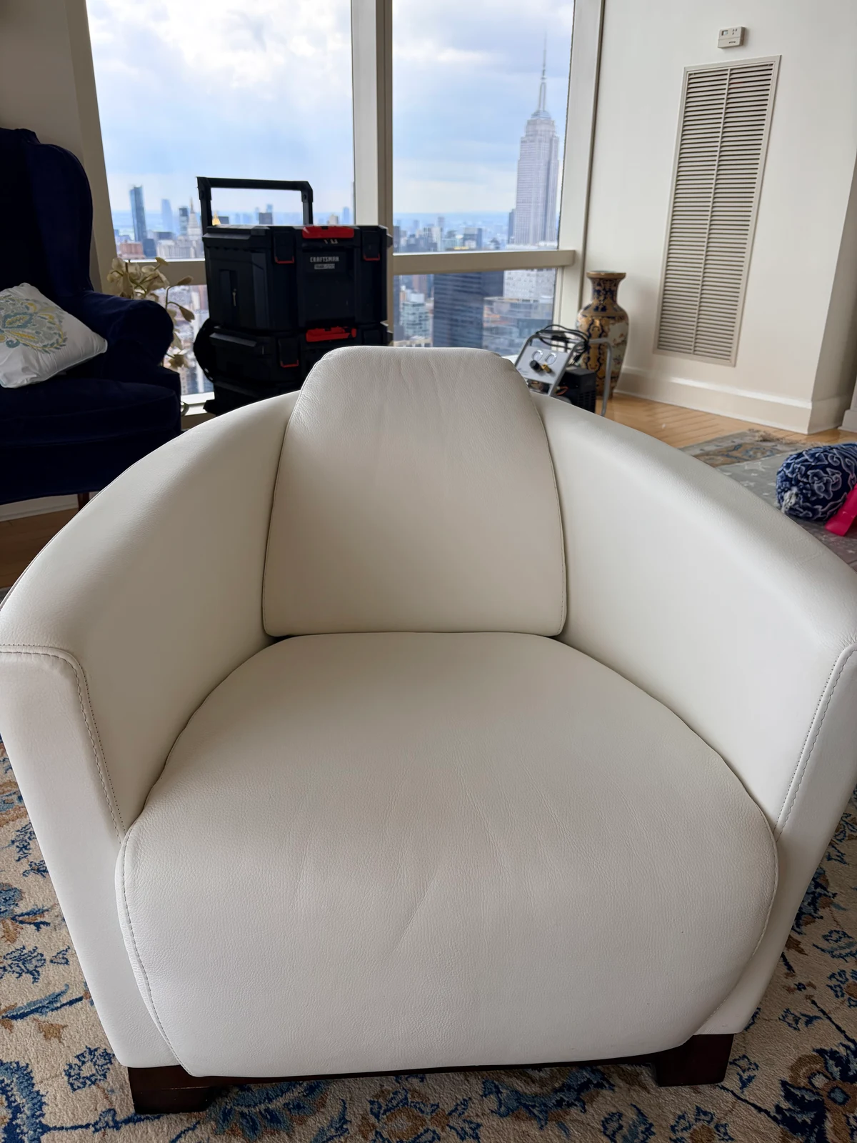 White leather lounge chair in a Manhattan high-rise after hair-dye stain and color restoration, overlooking the NYC skyline