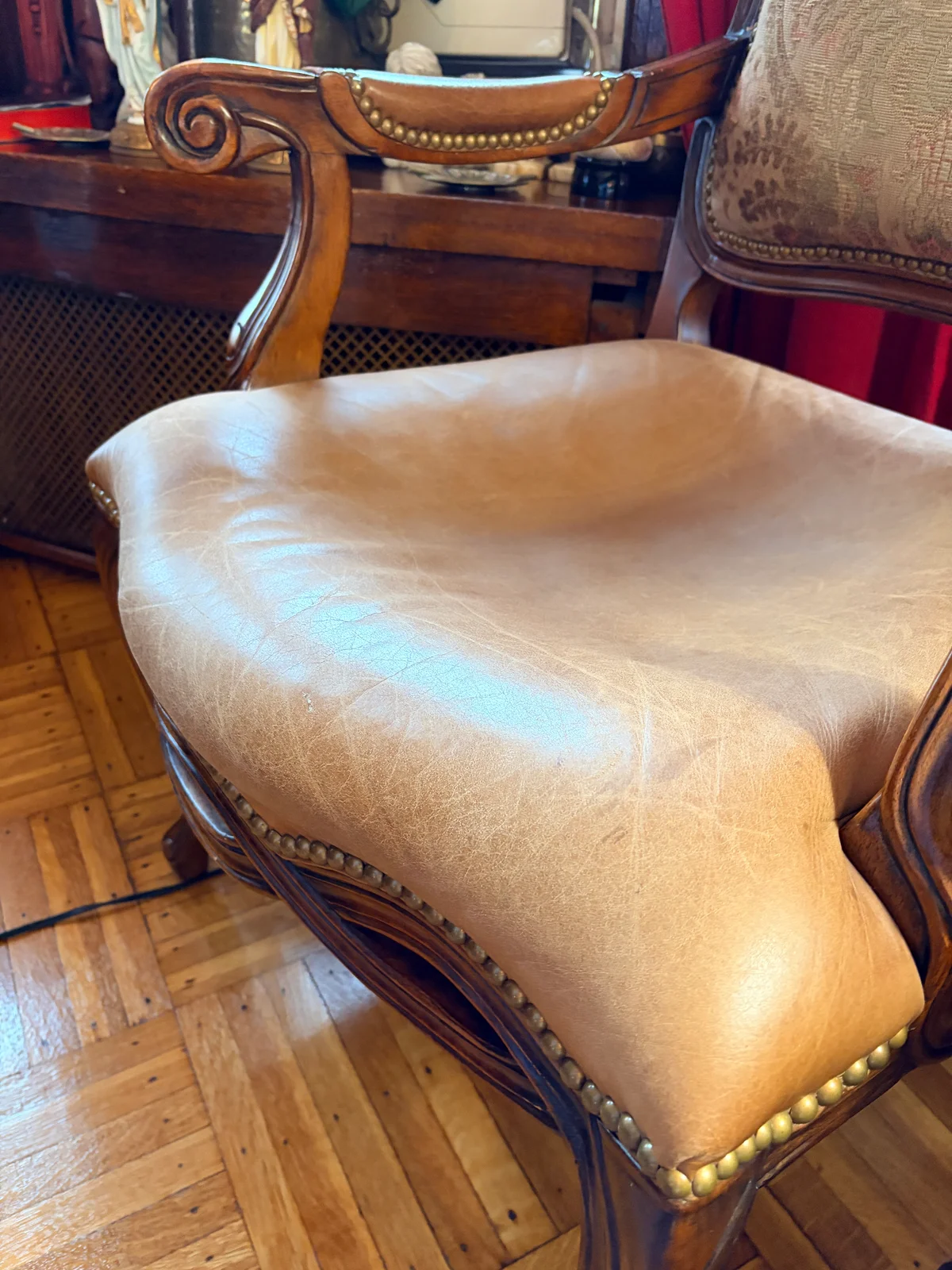Close-up of dining chair seat before foam replacement — leather draped flat over depleted foam with no cushioning support remaining